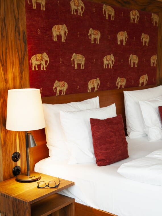 柏林 Orania 酒店的客房。大象墙纸和温暖的红色调。