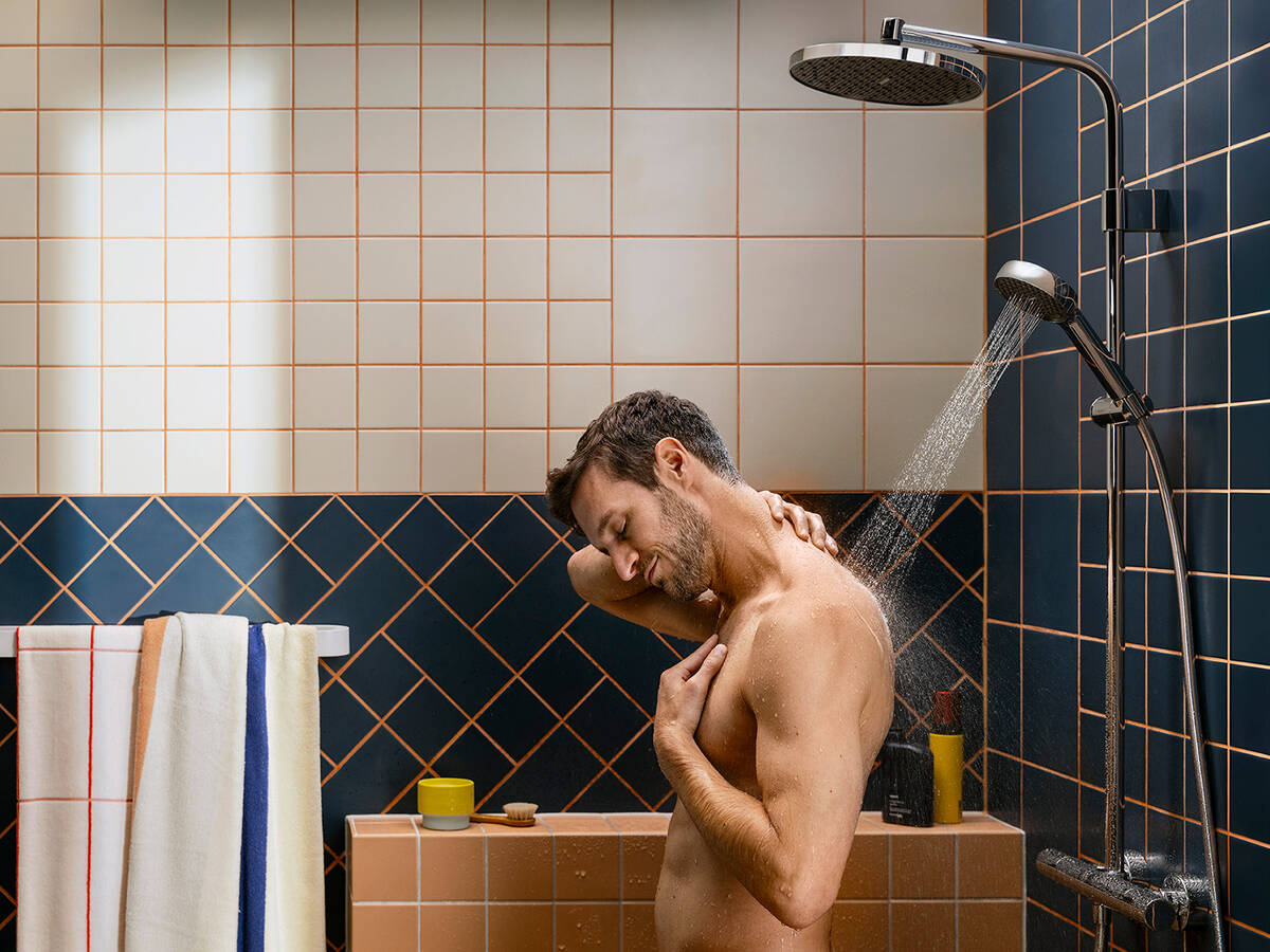 男士站在淋浴下。