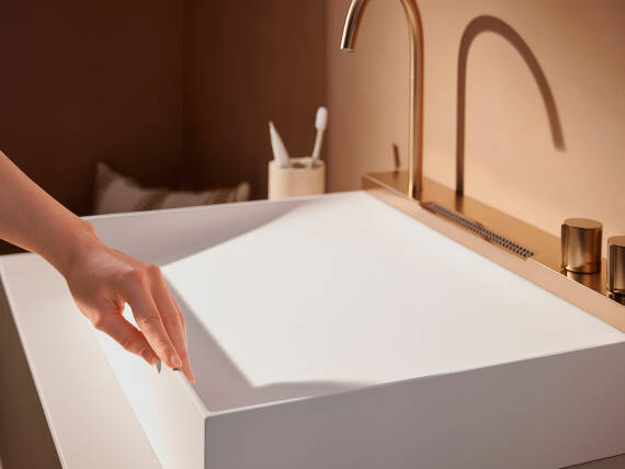 女士的手抚过汉斯格雅面盆的边缘。