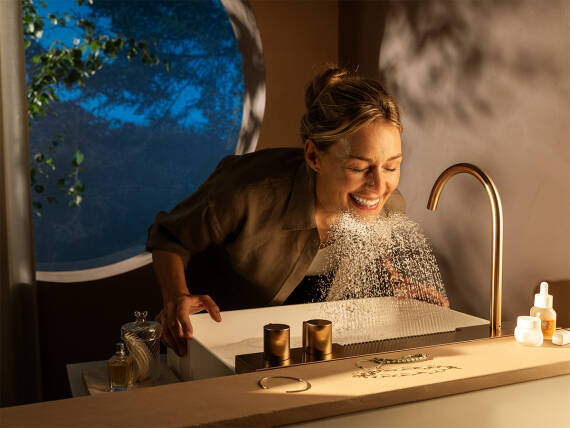 一位女士正在使用 Avalegra AquaUnit 洗脸，心情愉悦。