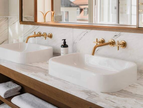 拉丝金色表面与大理石和橡木营造的环境形成鲜明对比。