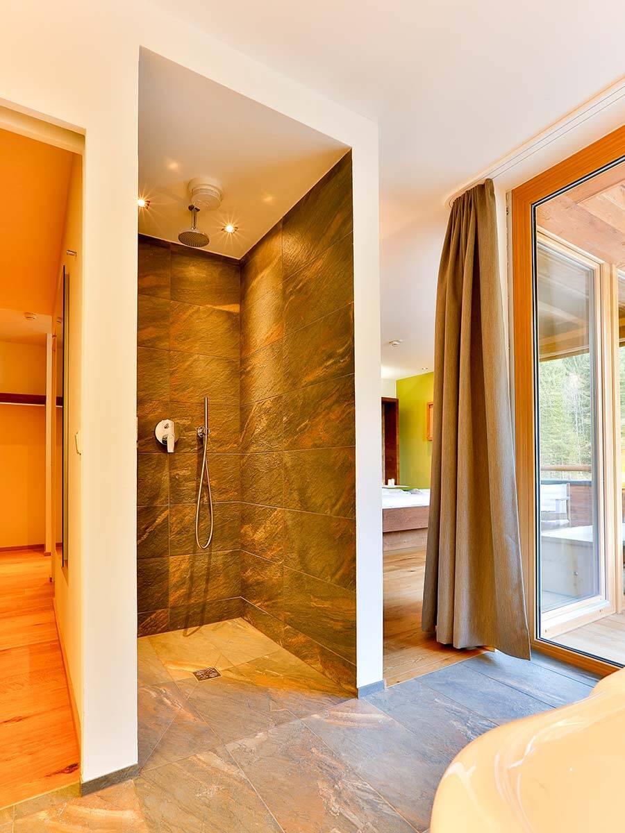 配有天然石材表面和镀铬龙头的淋浴房。