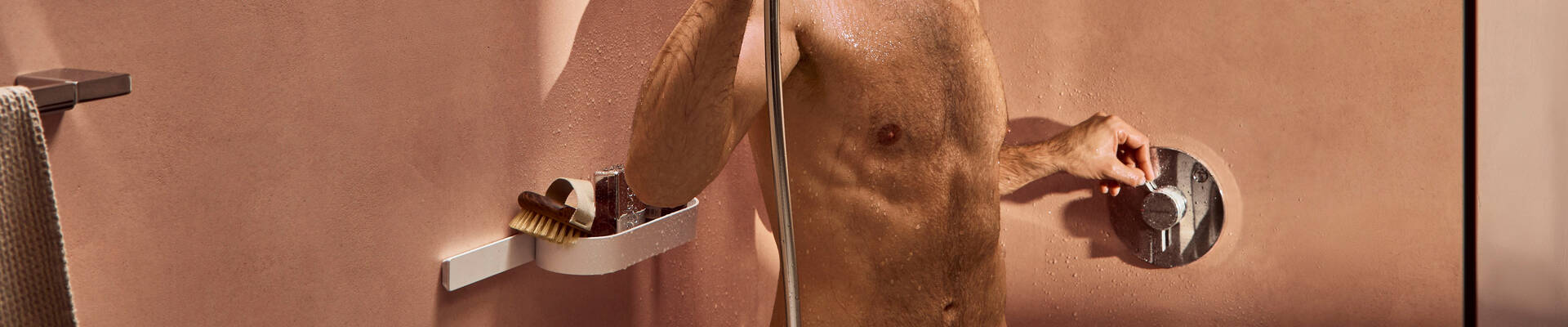 男士操作淋浴房中的 DuoTurn 暗装龙头。