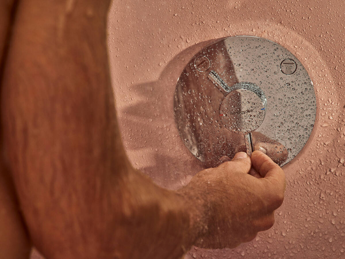 男士在淋浴下操作汉斯格雅 Duo Turn 龙头。