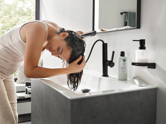 女士使用汉斯格雅抽拉式花洒洗头。