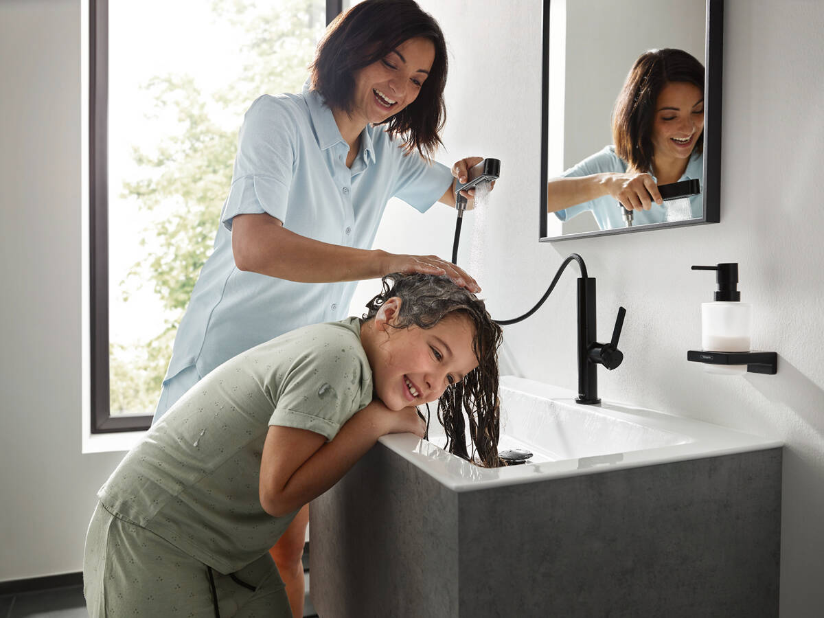 小女孩使用沄雨式喷淋洗掉头发上的香波。