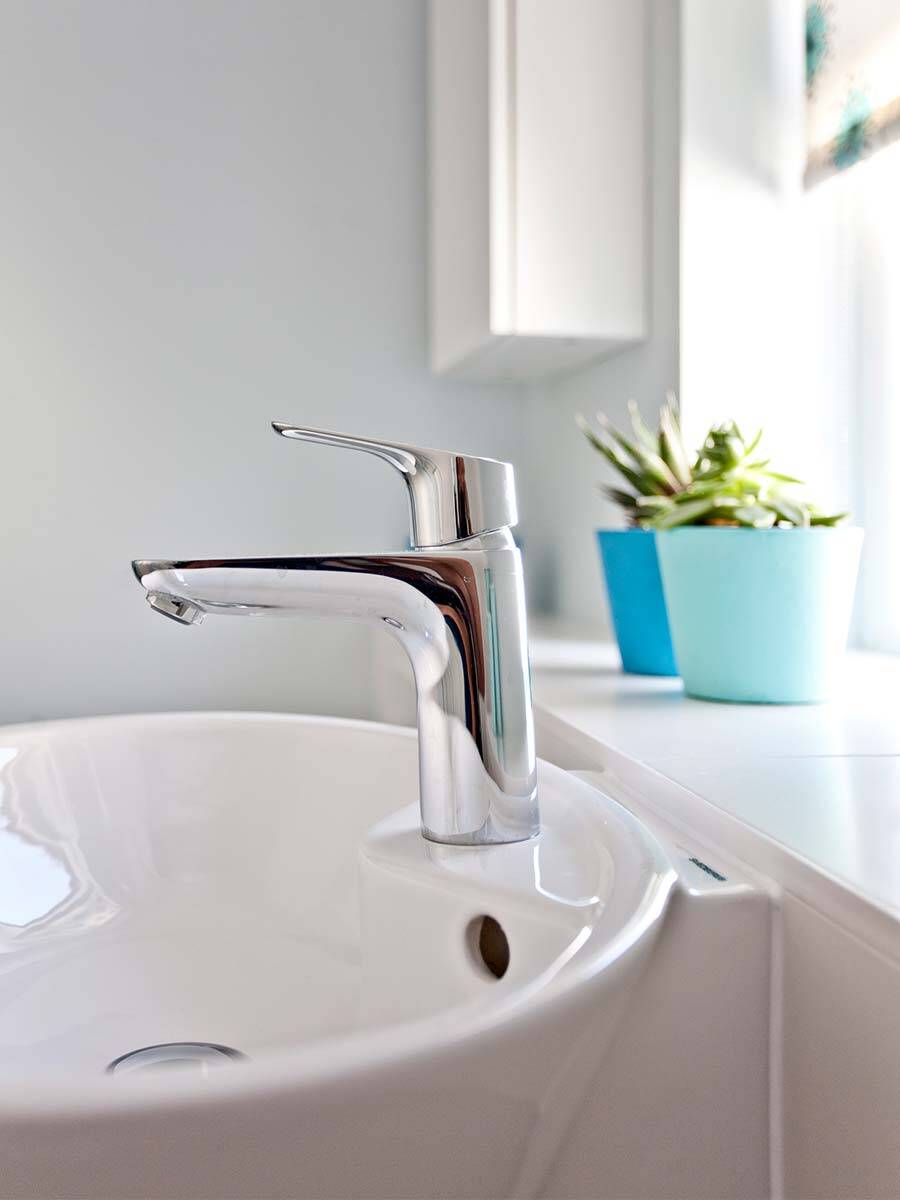 典雅的镀铬龙头在质朴的白色台盆旁。