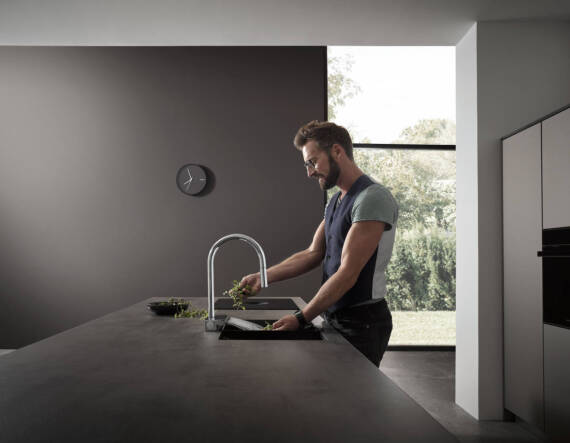 Man working in an open-plan, well-lit kitchen.