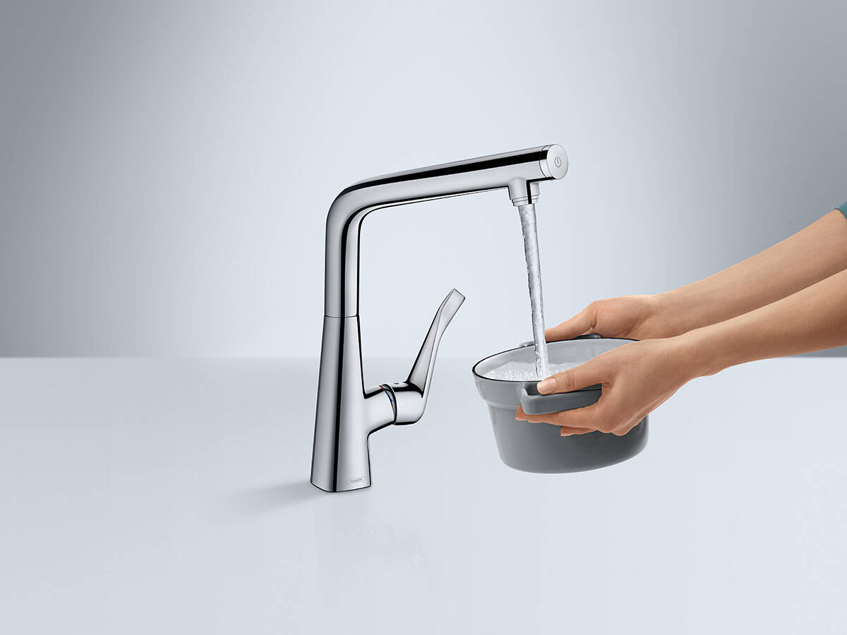 带优选按钮的梦迪诗水槽龙头向锅具注水。