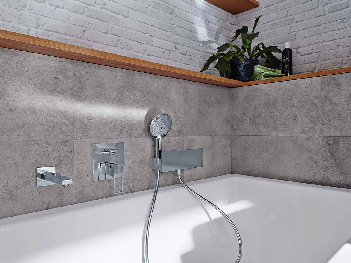 现代龙头和手持花洒在石灰色的背景下。