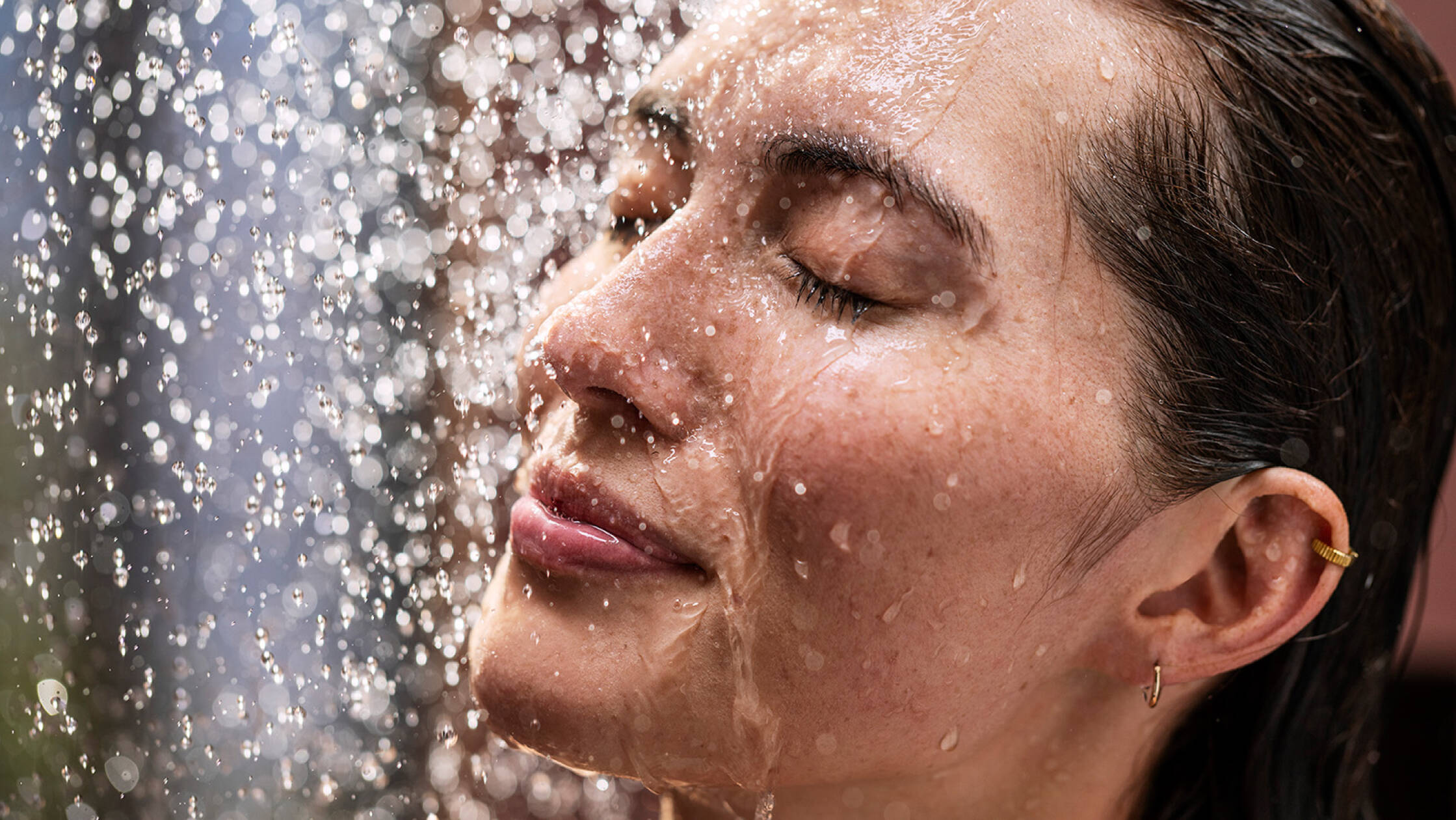 淋浴中的女士正在享受水滴轻抚面庞的快感。