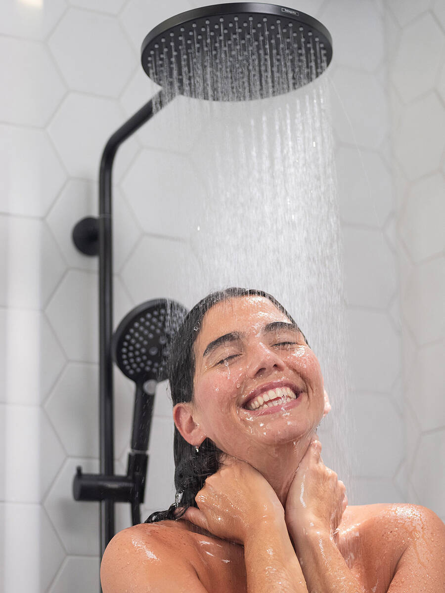 Woman enjoying the Raindance Select S shower pipe.