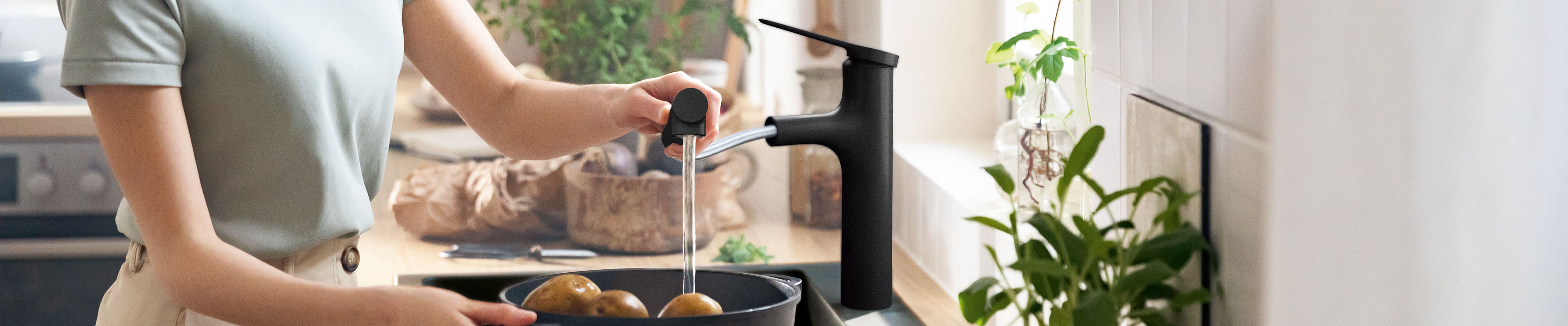 配有抽拉式花洒的 Zesis M33，哑光黑，在水槽上。