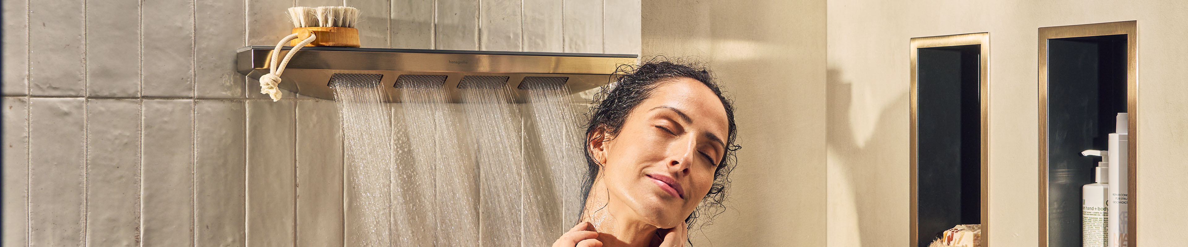 女士享受体位花洒的汉斯格雅喷淋形式。