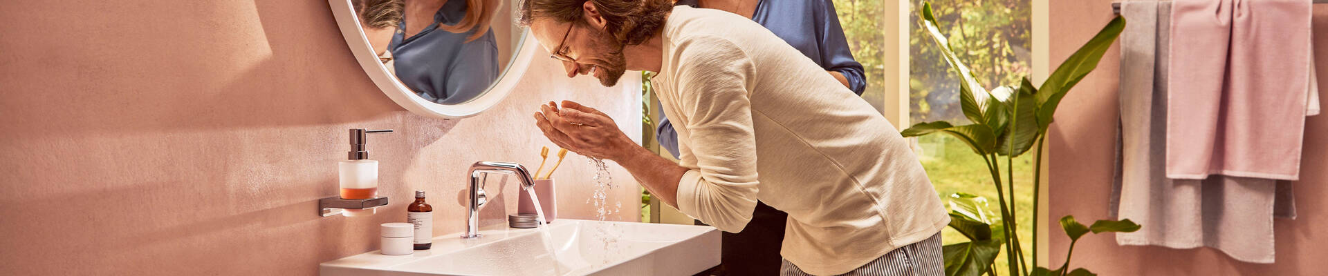 男士在配有 Tecturis S 台盆龙头的汉斯格雅台盆处。